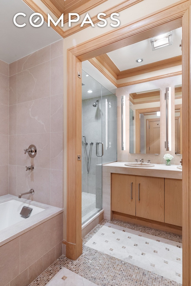 bathroom featuring a shower stall, a relaxing tiled tub, ornamental molding, tile patterned floors, and vanity