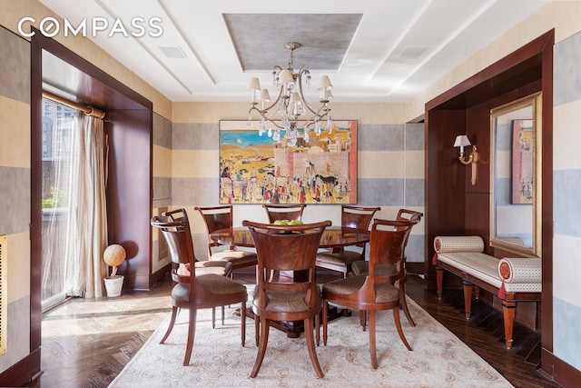 dining area featuring baseboards, a raised ceiling, a chandelier, and parquet flooring