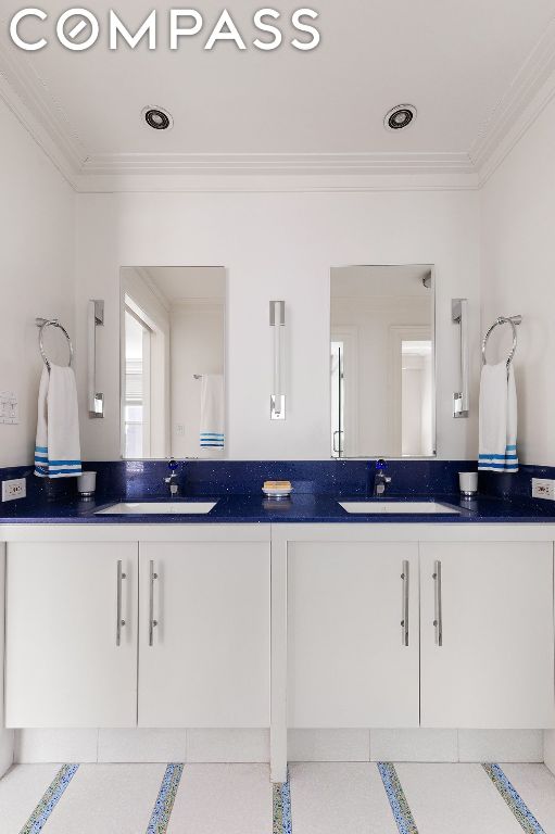 bathroom with crown molding and vanity