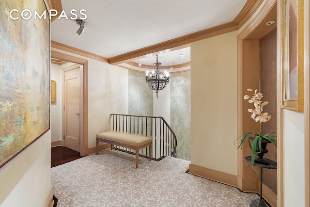 hall with an inviting chandelier, crown molding, and baseboards