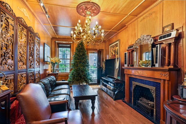 kitchen with sink, hanging light fixtures, premium appliances, a notable chandelier, and wall chimney range hood