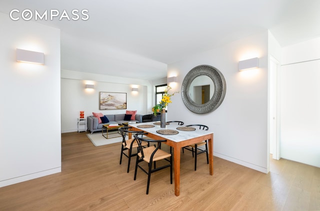 dining space featuring baseboards and light wood-style floors