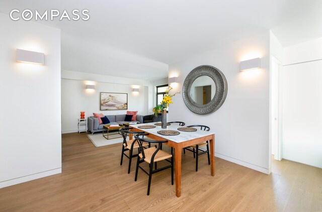 dining space featuring light wood finished floors and baseboards