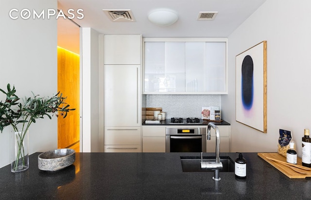 kitchen featuring white cabinetry, sink, stainless steel appliances, and decorative backsplash