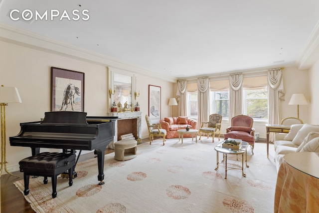 sitting room featuring baseboards, crown molding, and wood finished floors