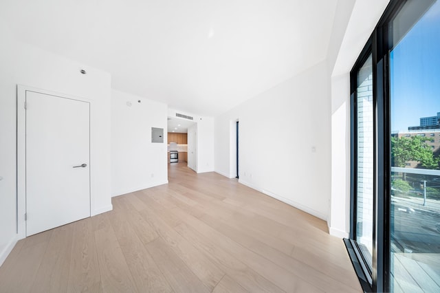 spare room featuring light wood-style flooring and baseboards