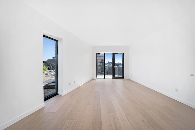 unfurnished room with light wood-style flooring and baseboards