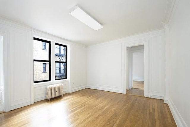 empty room with radiator heating unit and light hardwood / wood-style floors