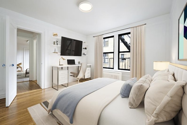 bedroom featuring hardwood / wood-style flooring and radiator heating unit