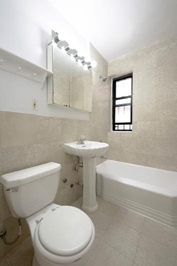 full bath with toilet, tile walls, and tile patterned flooring