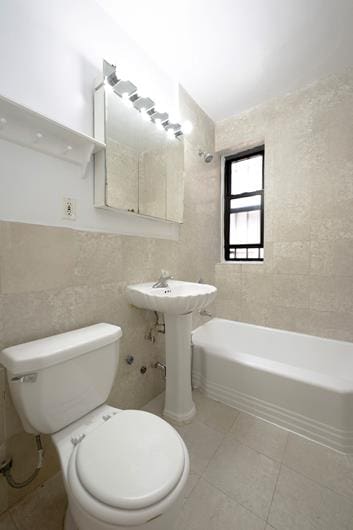 315 E 56th St Unit 6-B, New York City, NY 10022 - full bathroom with tile walls, toilet, and tile patterned flooring