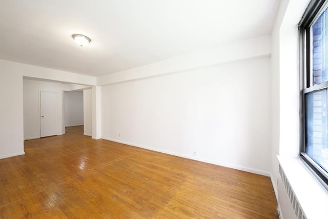 unfurnished room with light wood finished floors and baseboards