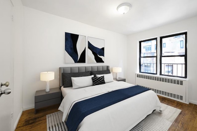 bedroom featuring radiator, baseboards, and wood finished floors