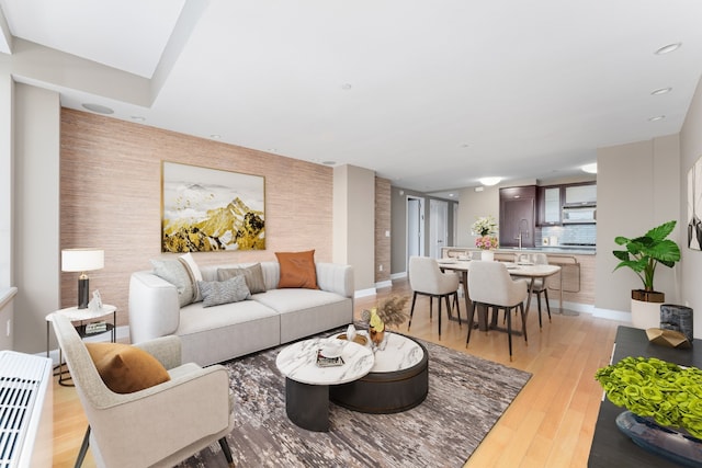 living room featuring sink and light hardwood / wood-style flooring