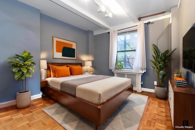 bedroom featuring beam ceiling and light parquet flooring