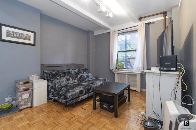 sitting room featuring beam ceiling and radiator