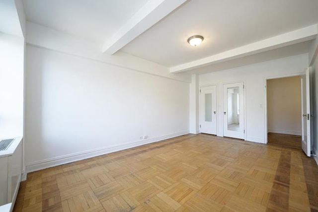 unfurnished bedroom with light parquet flooring and beamed ceiling