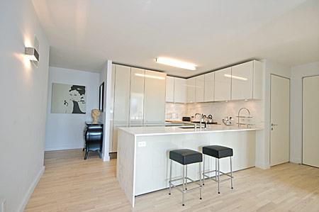 kitchen featuring a breakfast bar area, light wood-type flooring, decorative backsplash, and white cabinets