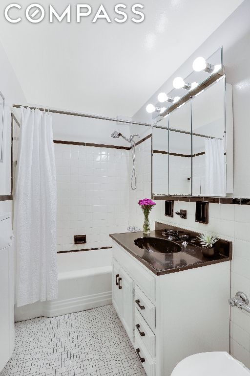 full bathroom with toilet, vanity, and shower / tub combo