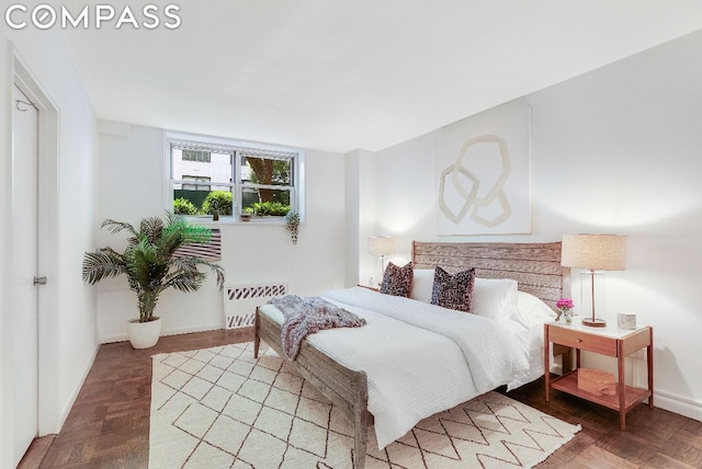 bedroom featuring radiator and parquet floors