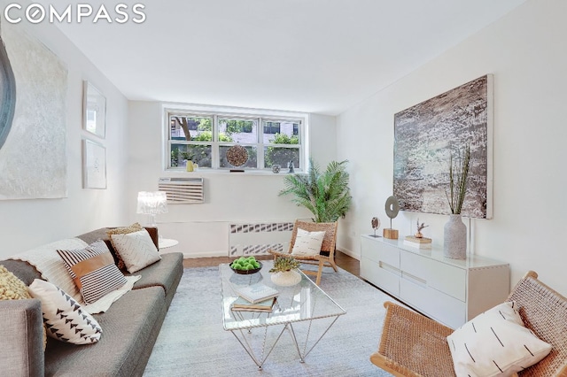 living room featuring an AC wall unit and radiator heating unit