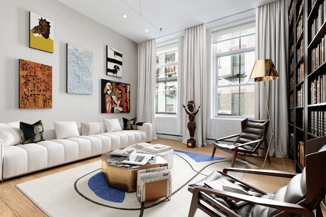 sitting room with hardwood / wood-style flooring and a baseboard heating unit