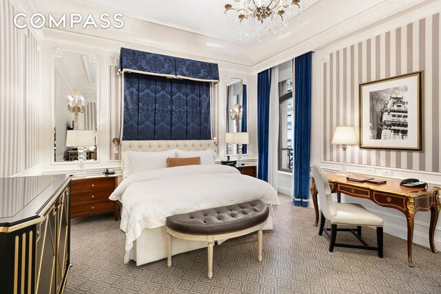 bedroom featuring crown molding, carpet floors, and an inviting chandelier