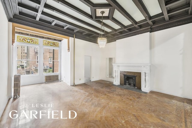 unfurnished living room with coffered ceiling, beam ceiling, radiator, a fireplace, and a high ceiling