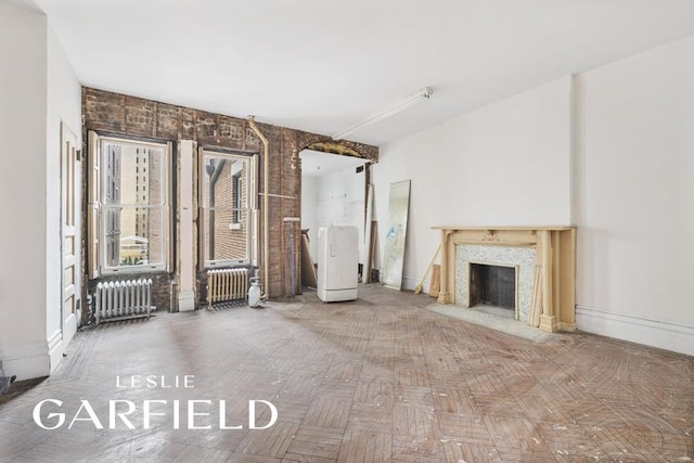 8 W 71st St, New York City, NY 10023 - unfurnished living room featuring radiator heating unit, a premium fireplace, and baseboards