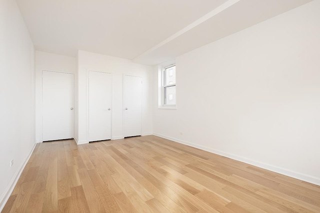 unfurnished bedroom with baseboards and light wood-style floors