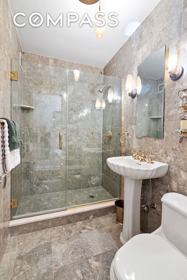 bathroom featuring toilet, tile walls, and a stall shower