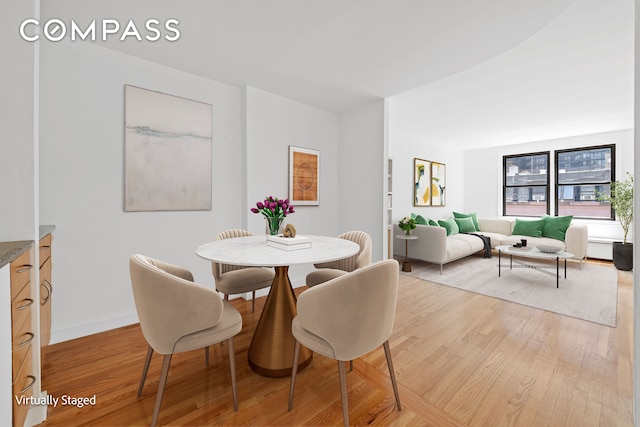 dining area with light wood finished floors and baseboards