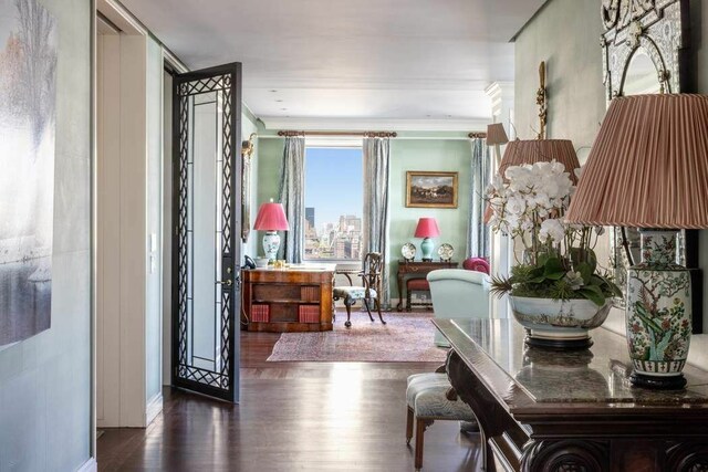 living area with crown molding and a water view