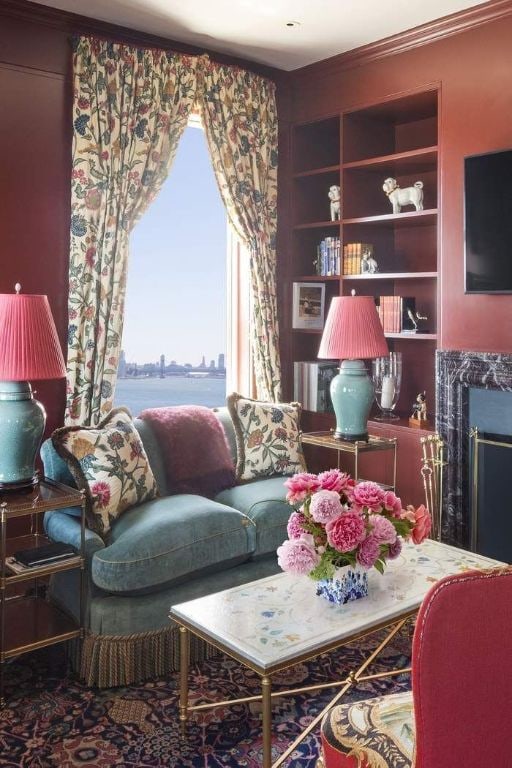 living room featuring ornamental molding, a water view, a high end fireplace, and built in shelves