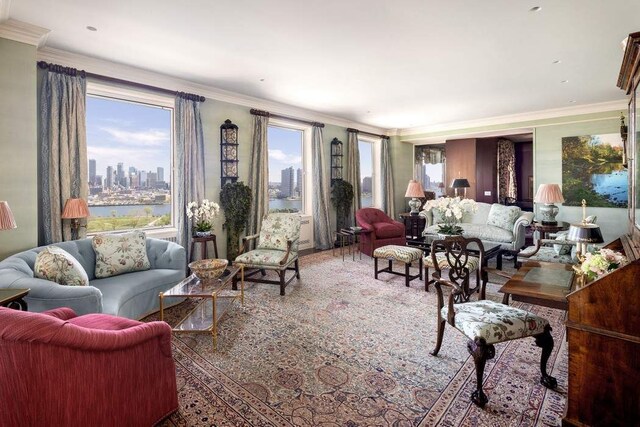 living room featuring ornamental molding, a water view, a high end fireplace, and built in shelves