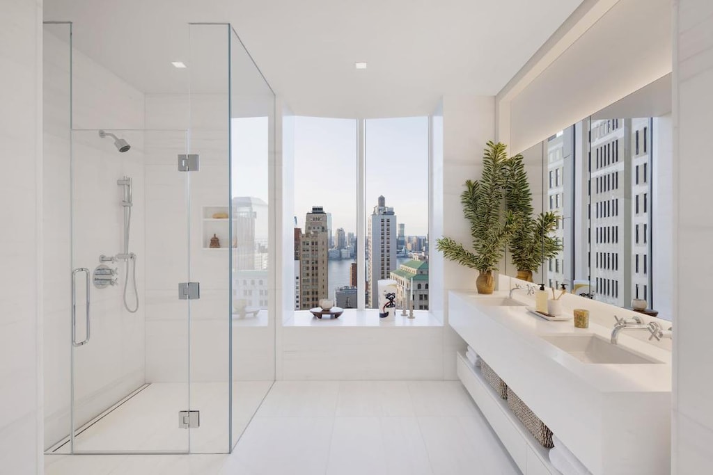 bathroom featuring a wall of windows, vanity, tile patterned flooring, and plus walk in shower