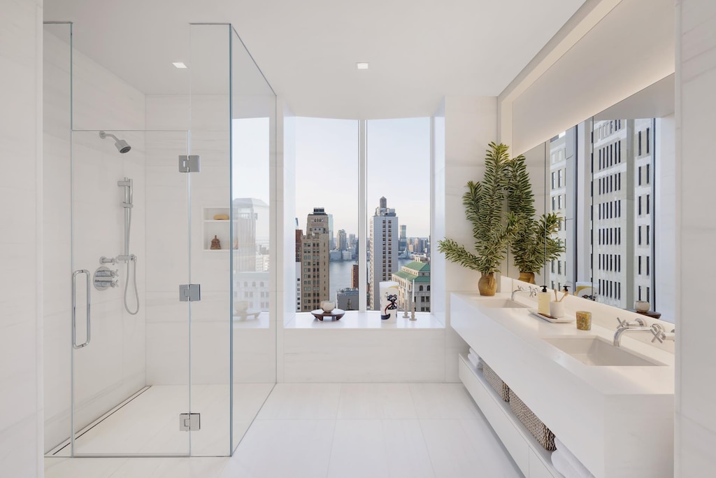 ensuite bathroom featuring a city view, a stall shower, ensuite bathroom, a sink, and tile patterned flooring