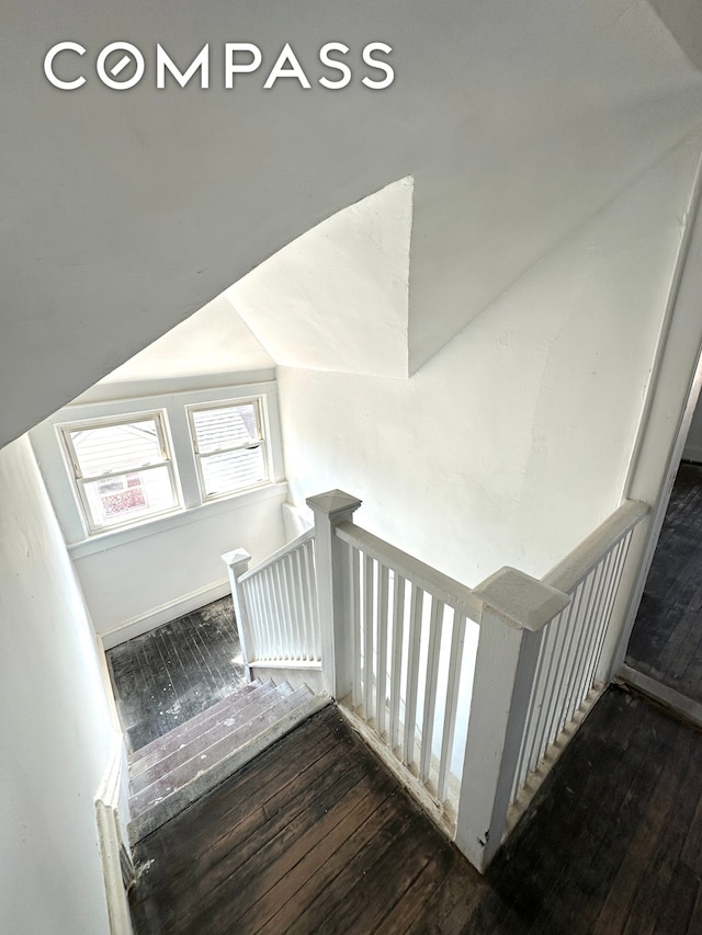 stairway featuring vaulted ceiling and hardwood / wood-style floors