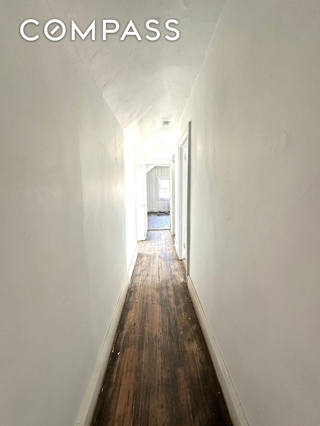 corridor featuring hardwood / wood-style flooring and baseboards