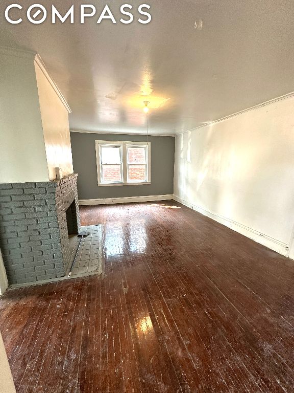 unfurnished living room with dark wood-type flooring and a fireplace