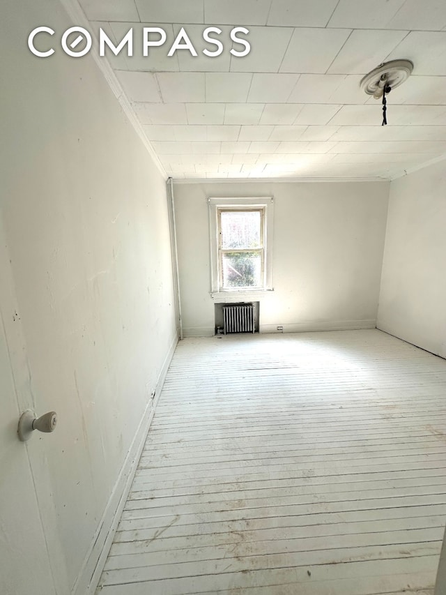 interior space with radiator and wood finished floors