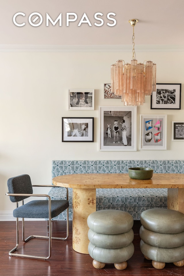 living area featuring crown molding, dark wood-type flooring, and a chandelier