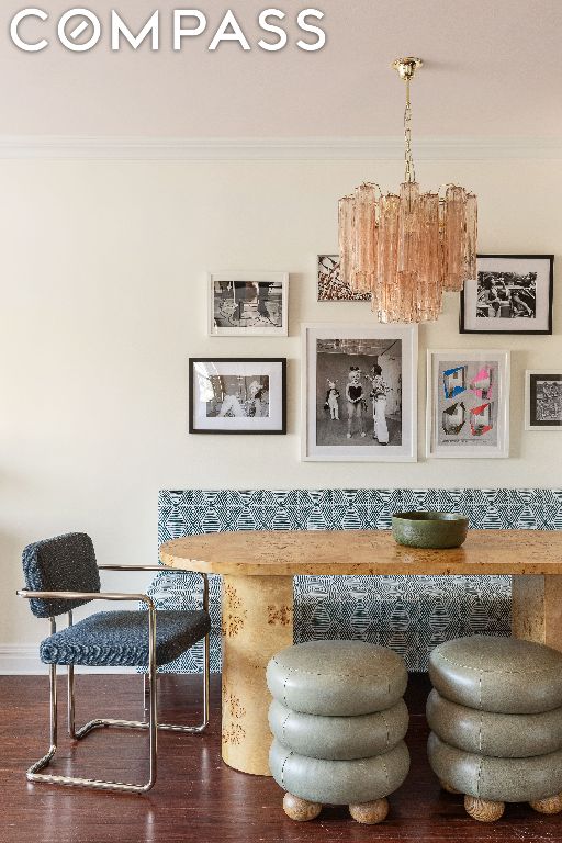 dining space featuring hardwood / wood-style flooring, crown molding, and an inviting chandelier