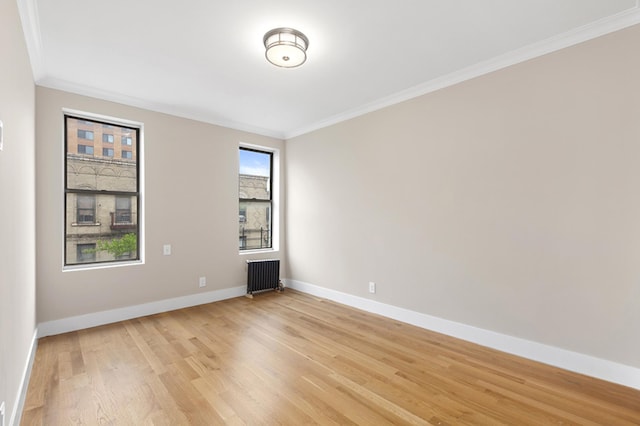 unfurnished room with light wood-type flooring, radiator heating unit, baseboards, and ornamental molding