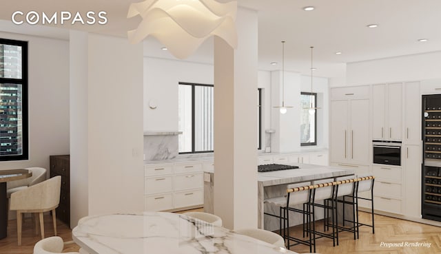 kitchen featuring a kitchen bar, stainless steel oven, light stone countertops, and white cabinetry