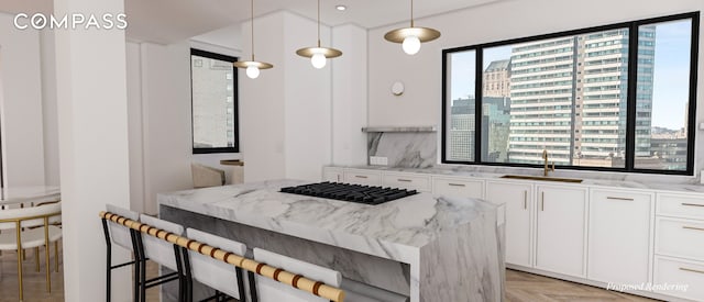 kitchen featuring a kitchen breakfast bar, white cabinets, and a sink