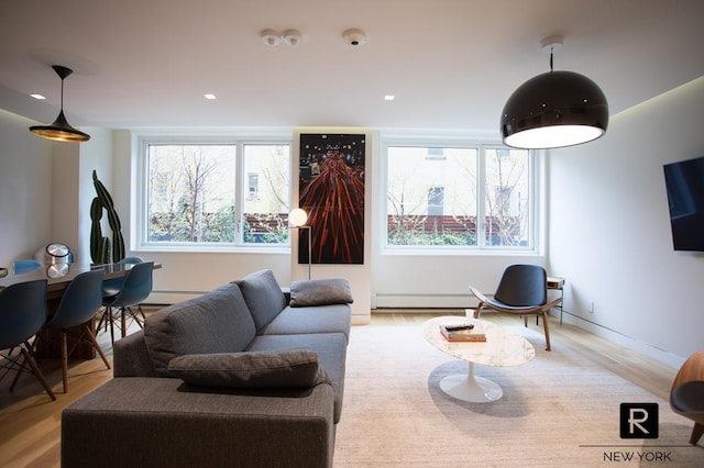 living room featuring plenty of natural light, wood finished floors, and a baseboard radiator