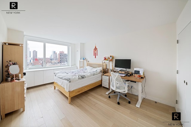 bedroom featuring light wood-style flooring and a desk