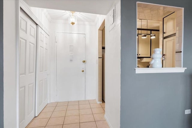 hallway featuring crown molding and light tile patterned floors