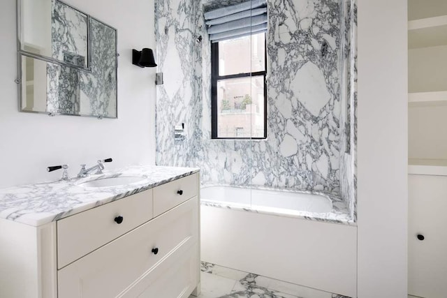 bathroom with vanity, a tub, and marble finish floor